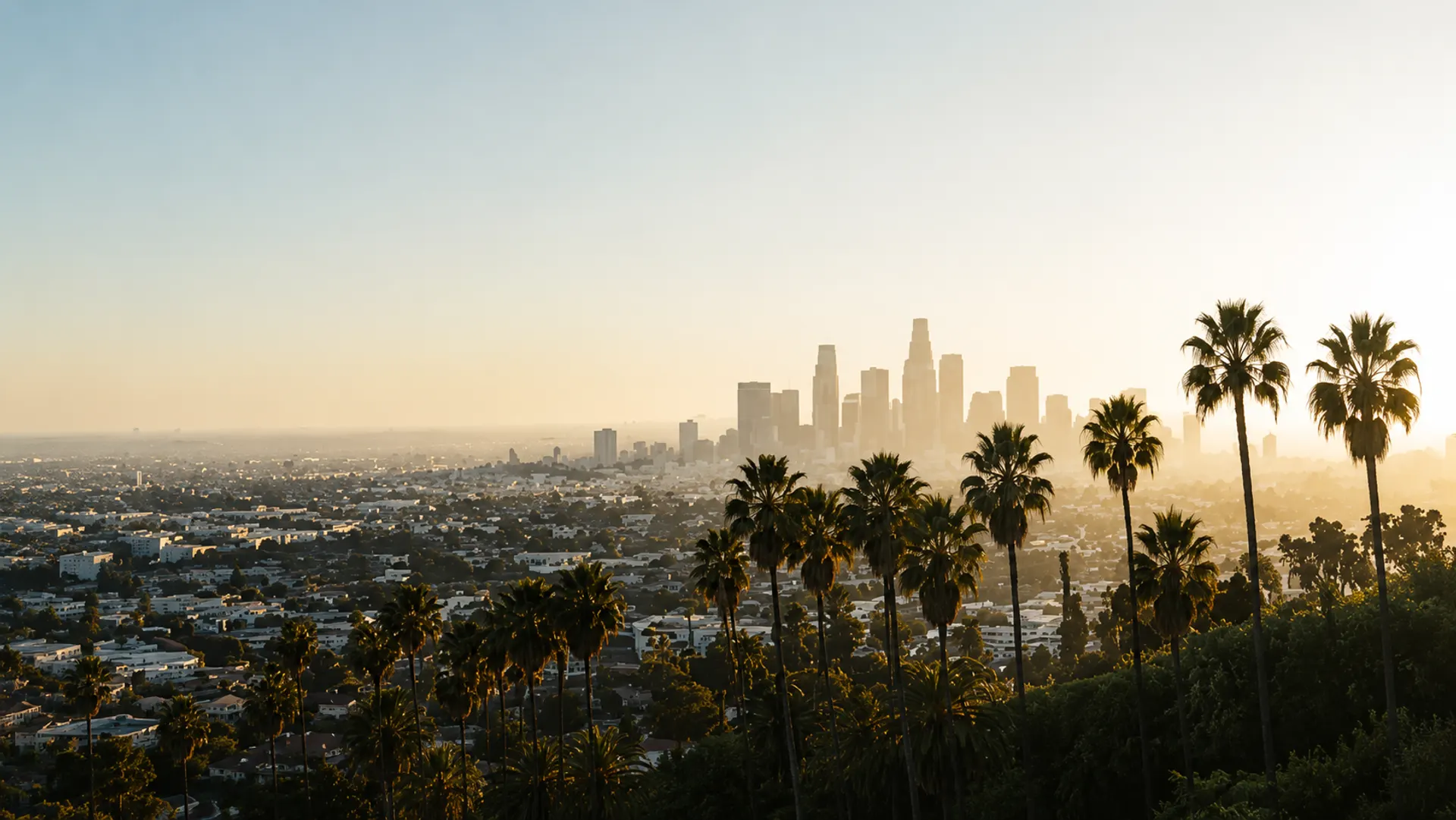 Los Angeles skyline at golden hour with palm trees, home to the luxury and collectables markets connected through PAIWE's liquidity network.